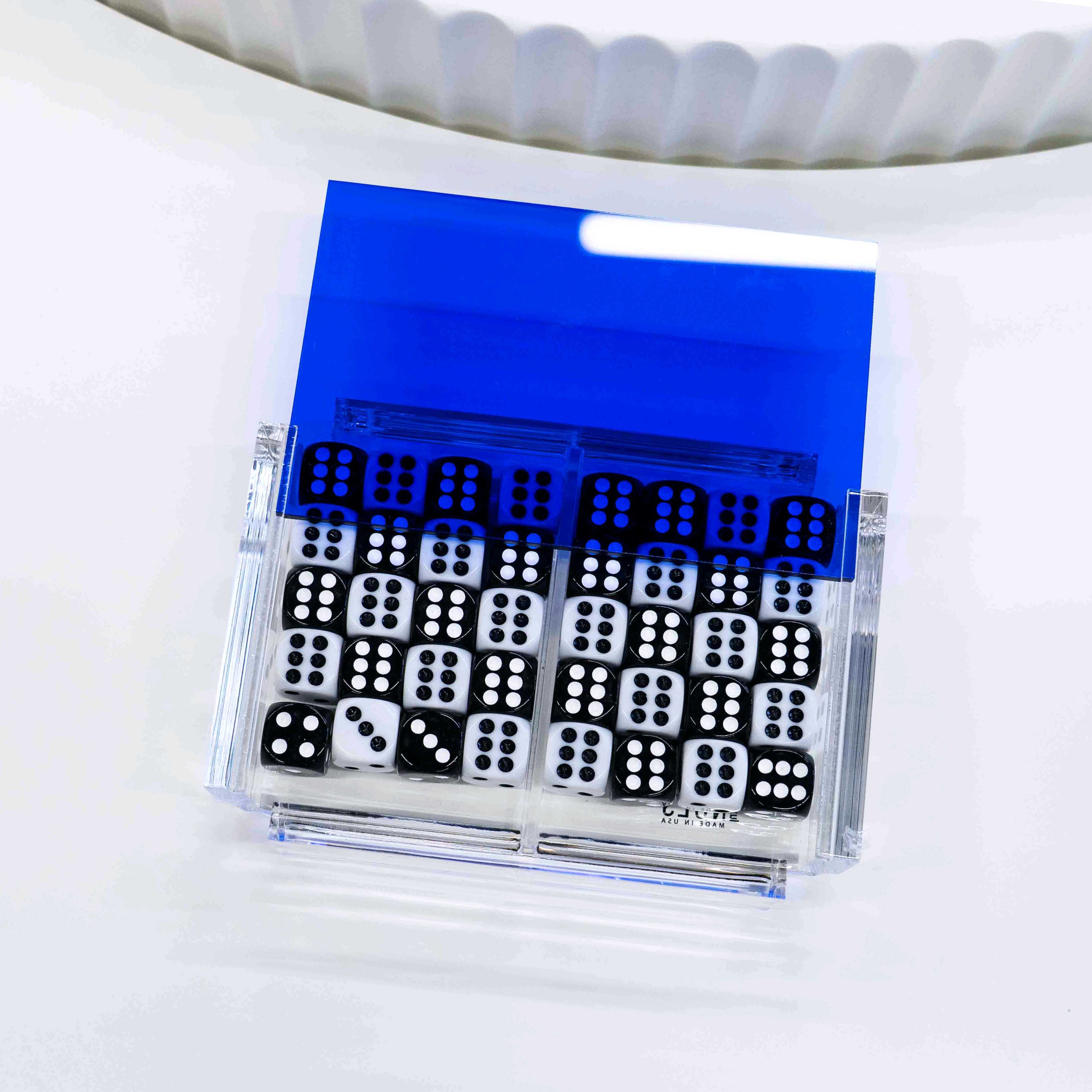 Open acrylic dice case showing black and white dice inside
