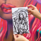 Person holding a black and white illustration of an astronaut on a colorful background