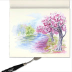 Example of a colorful illustration of a cherry blossom tree on a piece of paper with a paintbrush.