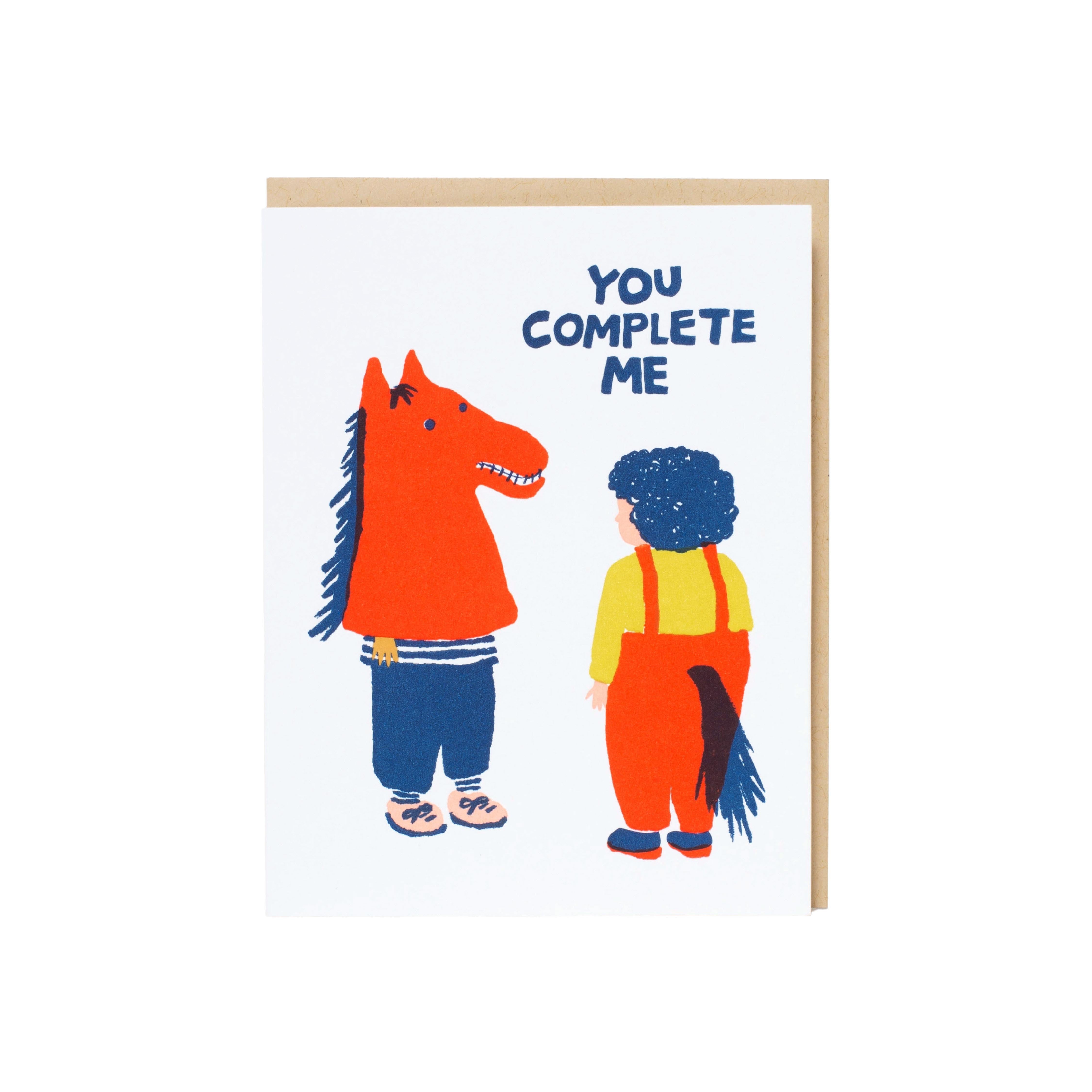 Greeting card with illustrated horse-costume character and partner, with text ‘You complete me.’ Main image